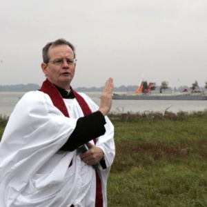 Páter Patrick Curran počas obradu, ktorý ordinoval